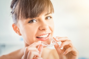 Woman putting on her Invisalign tray